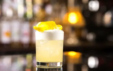 Klasyczny whisky sour przepis: orzeźwiający koktajl z pianką i skórką cytryny, idealny na każdą okazję.