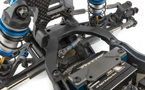 Detailaufnahme des Fahrwerks eines RC-Autos. Stoßdämpfer, Carbonteile und ein HV Digital Brushless Servo sind sichtbar. Die Nummer #71157 ist auf einem Teil eingraviert.