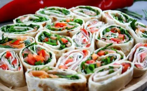 Szybkie przekąski z tortilli na zimno: rolki z łososiem, rukolą i papryką. Idealne na imprezę lub jako lekki lunch.
