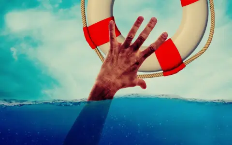 Dłoń wyciągnięta z wody chwyta koło ratunkowe. To symbol nadziei i szansy na nowe życie, jak w przypadku wczasów odwykowych dla alkoholików.
