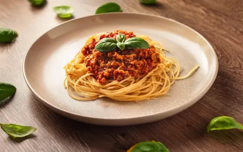 Pyszne spaghetti bolognese, idealne na prosty obiad. Aromatyczny sos mięsny z pomidorami i świeża bazylia.