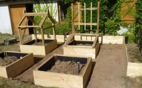 Nouveau potager en carré prêt à être planté. Structures en bois pour protéger les futures cultures.
