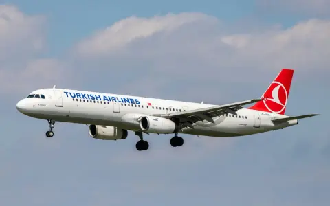 Turkish Airlines flygplan med landningsstället nere, redo för landning. Perfekt för din turkish airlines handbagage-resa.