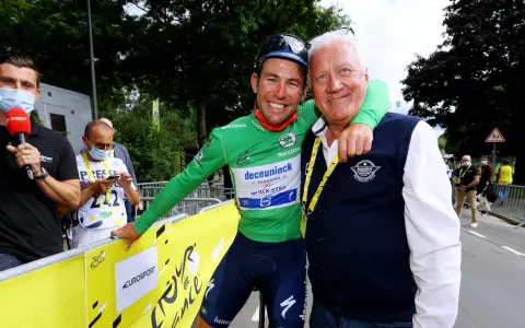 Cyclist in green jersey with Patrick Lefevere, both smiling.