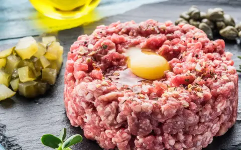 Un delicioso steak tartar con huevo crudo, alcaparras, pepinillos y aceite de oliva.