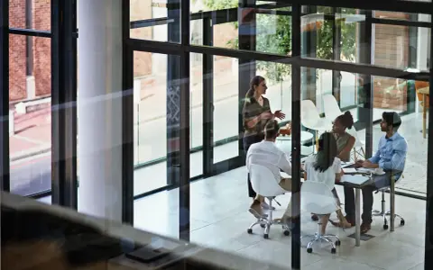 A team discusses network infrastructure solutions in a modern office meeting room.