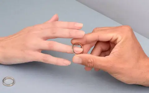 Manos unidas, un anillo dorado listo para ser colocado en el dedo anular, el lugar donde se pone el anillo de compromiso.