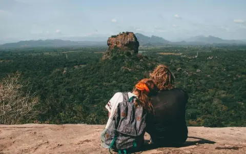 Coppia ammira Sigiriya, una delle meraviglie da vedere in Sri Lanka. Paesaggio lussureggiante e roccia imponente.