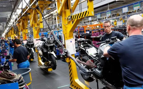 Männer arbeiten an Motorrädern in einer Fabrik. An Christi Himmelfahrt muss man anscheinend arbeiten.