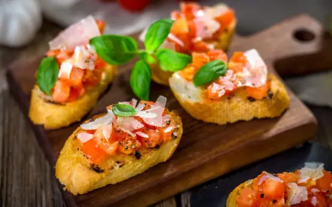 Bruschetta med färska tomater, basilika och parmesan på rostat bröd. Ett enkelt och gott bruschetta recept för alla tillfällen.