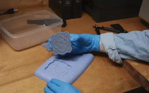 Manos enguantadas muestran un molde de silicona recién hecho, demostrando cómo hacer moldes de silicona para crear piezas decorativas.