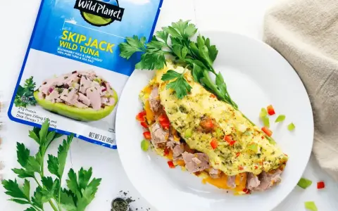 Pyszny omlet z tuńczykiem, papryką i ziołami, obok opakowanie tuńczyka Wild Planet.