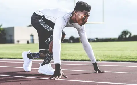 En sprinter i startblocken, redo för en explosiv anaerob sprint. Träningen balanserar aerob och anaerob kondition.