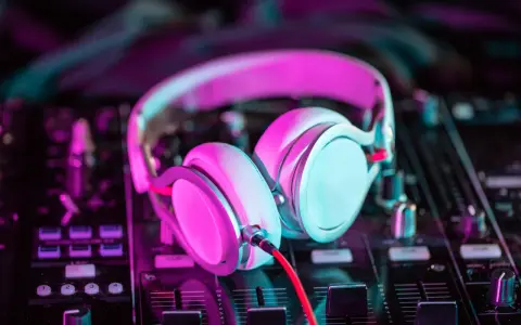 Słuchawki na mikserze, gotowe do tworzenia pulsującej muzyki elektronicznej w neonowym świetle.