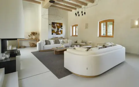 Salón moderno con sofás blancos, chimenea y suelo de microcemento sobre azulejos.