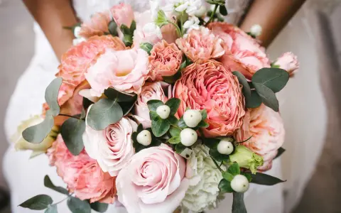 En vacker bukett med rosa rosor, nejlikor och eukalyptus. Perfekta blommor till dukning för ett romantiskt bröllop.