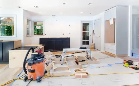 Chantier d'un appartement en rénovation : armoires sombres, structure en bois, aspirateur, outils. Idéal pour des conseils rénovation appartement.