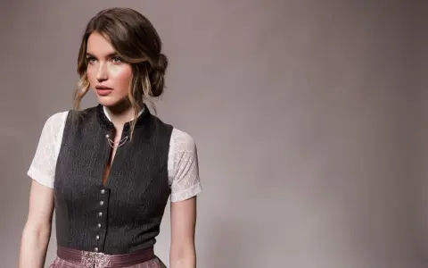 Eine Frau mit einer eleganten Dirndl-Frisur für kurze Haare trägt ein traditionelles Dirndl.