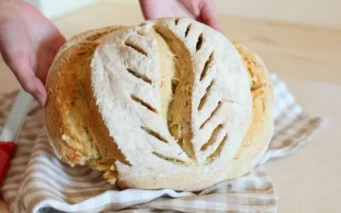 Pane fatto in casa, fragrante e dorato, con tagli che ricordano la ricetta della nonna.