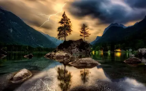 Dramatyczne zdjecia hdr: błyskawica nad skalistą wyspą z drzewami na środku jeziora, otoczonego górami.