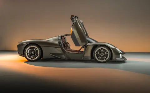 Porsche 918 Spyder z otwartymi drzwiami, widok z boku, w brązowym kolorze.