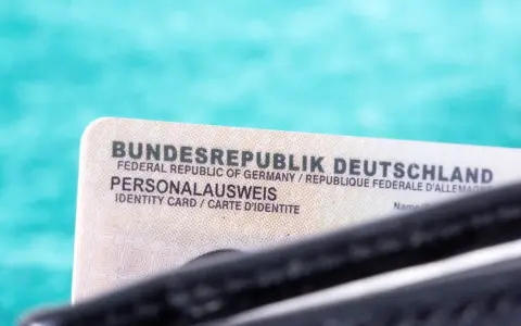Niemiecki dowód osobisty (Personalausweis) na tle turkusowym.