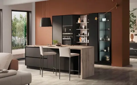 Elegante zona giorno open space con cucina moderna, isola centrale in legno e soggiorno accogliente.