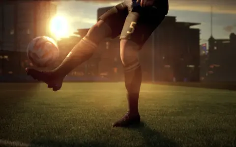 Jugador de fútbol con el número 5 en su pantalón corto, pateando un balón en un campo al atardecer. El sol brilla intensamente detrás de los edificios de la ciudad. ufl pc.