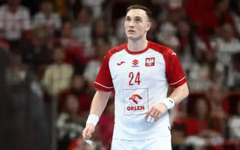 Wiktor Jankowski, numer 24, w białej koszulce z czerwonymi rękawami, z orłem na piersi, na tle trybun.