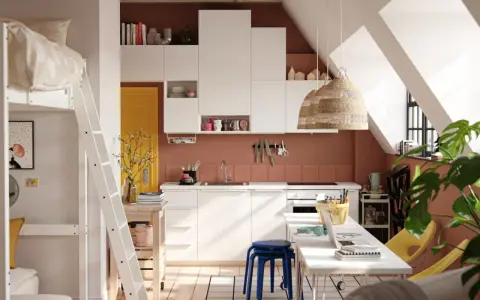 Aménager un studio : lit mezzanine, cuisine blanche, porte jaune, et coin bureau fonctionnel sous les combles.