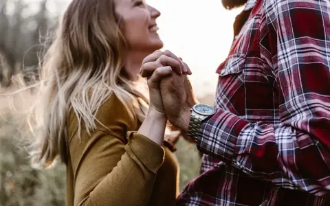 Glückliches Paar hält Händchen. Sie strahlt, er trägt kariertes Hemd. Vielleicht ein Zeichen für den Vaterkomplex bei Frauen?