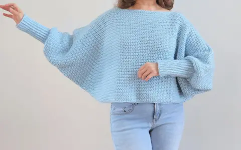 Niebieski sweter na szydełku z szerokimi rękawami. Ten sweter na szydełku wzór jest idealny na chłodne dni.