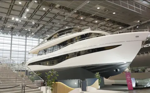 Luxuriöse Yacht, bereit für die boot 2026 Messe. Glänzende weiße Hülle, mehrere Decks und große Fenster.