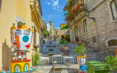 Colorate ceramiche artistiche adornano una scalinata a Taormina, un luogo incantevole per famiglie con bambini.