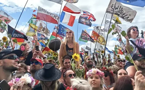 Tłum na festiwalu Poland Rock 2026, z flagami i słonecznikami. Ludzie cieszą się muzyką i atmosferą.
