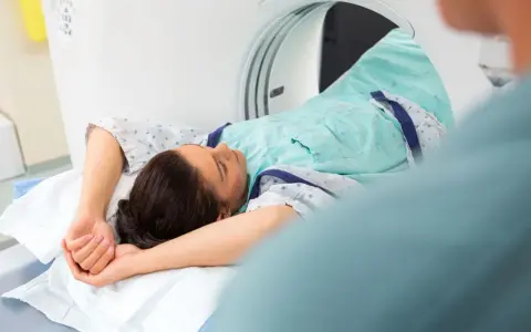 Pacjentka leży w skanerze tomografii komputerowej, badanie może pomóc zdiagnozować metaplazję pęcherza moczowego objawy.