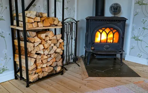 En kamin med glödande eld och en vedstapel redo för att installera kamin.