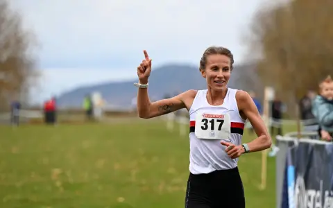 Sarah Lahti firar en seger, nummer 317, med ett leende och en uppsträckt arm.