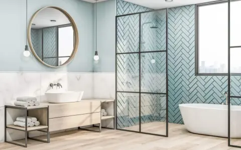 Salle de bain moderne avec baignoire îlot, douche vitrée et lavabo sur meuble en bois. Le mur derrière la douche est recouvert de **faïence** bleu sarcelle en chevrons.