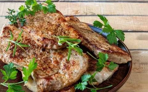 Soczysty schab z airfryer, idealnie przypieczony, podany z gałązkami rozmarynu i natki pietruszki. Pyszne i zdrowe danie.