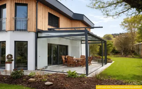Moderne Glasdach-Terrasse mit Holztisch und Stühlen. Nachteile wie Hitzeentwicklung im Sommer sind zu bedenken.