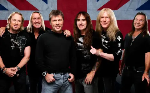 Sechs Musiker der Band Iron Maiden posieren vor der britischen Flagge.
