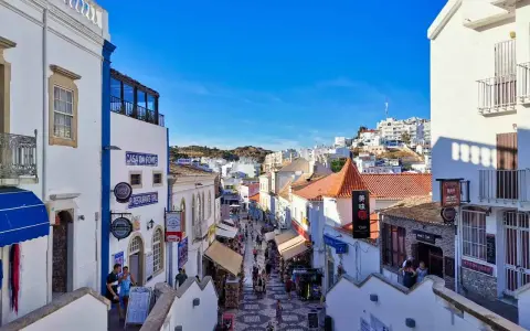 Bunte Gassen in Albufeira, Algarve, mit Geschäften und Restaurants, die sich den Hügel hinaufschlängeln.
