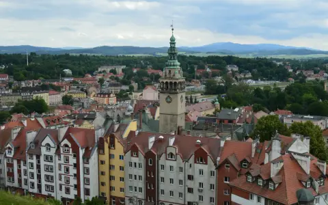 Widok na kłodzko stare miasto z charakterystyczną wieżą zegarową i kolorowymi kamienicami.