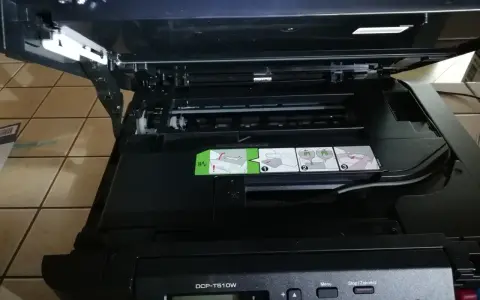 Otwarta drukarka Brother DCP-T510W z widocznymi instrukcjami i panelem sterowania.