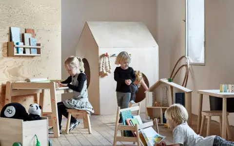 Dzieci bawią się i uczą przy stoliku sensorycznym IKEA FLISAT w pokoju zabaw.