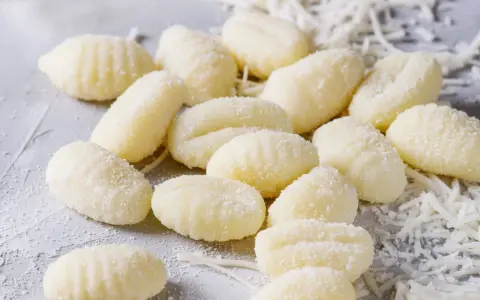 Frische, weiche Gnocchi-Pasta, bestreut mit etwas geriebenem Käse, bereit für ein köstliches Essen.