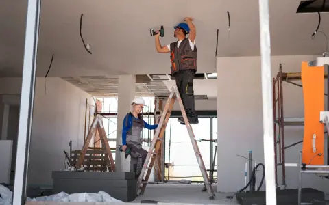 Dwaj budowlańcy pracują przy suficie. Czy jest ulga na remont mieszkania?
