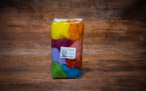 Paket med färgglad karda ull i regnbågens färger, perfekt för påskpyssel.