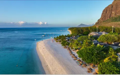 Rajska plaża na Mauritiusie, idealna temperatura do opalania. Woda kusi turkusowym blaskiem, a palmy szumią na wietrze.
